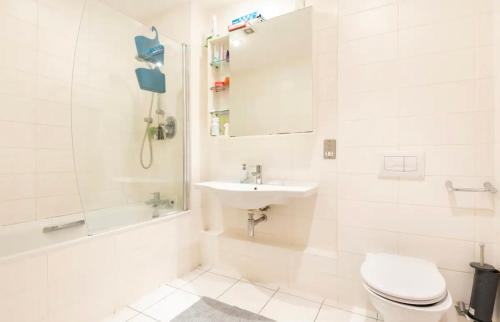 a white bathroom with a toilet and a sink at Spacious Room with Relaxing View in Dublin