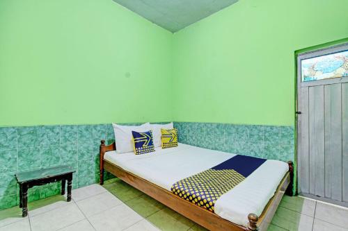 um quarto com uma cama num quarto com uma janela em SPOT ON 93029 Pondok Wisata Sabar Menanti 2 em Bantul