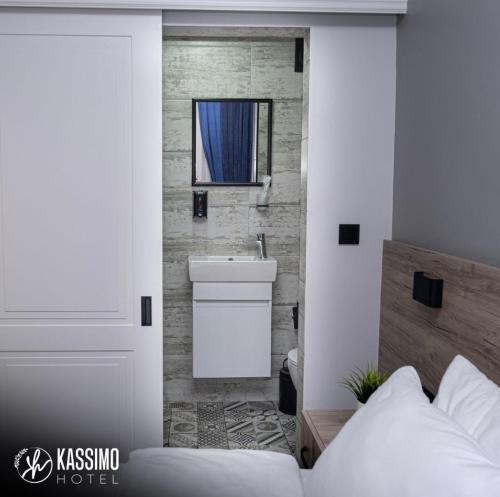 a bedroom with a bed and a sink and a mirror at Kassimo Hotel in Istanbul