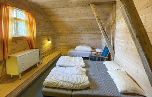 a bedroom with two beds in a wooden cabin at 2 Bedroom Awesome Home In Grue Finnskog in Svullrya