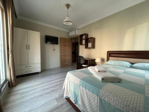 トラブゾンにあるBorahan Apartのベッドルーム1室(青と白の毛布付きのベッド1台付)