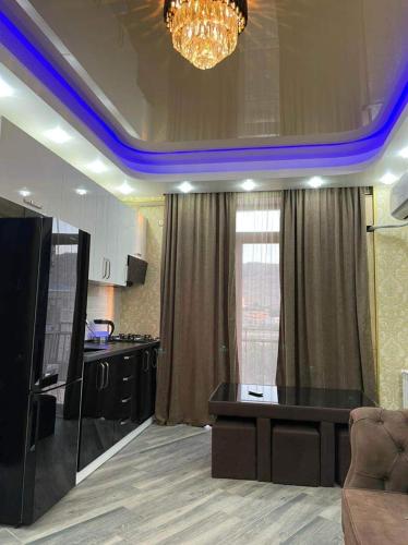 a living room with a kitchen with a chandelier at My Sweet Home In Rustavi sity 2 in Rustavi