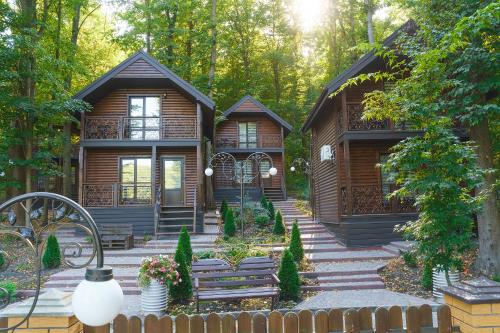 a cabin in the woods with a bench in front of it at Готельно-ресторанний комплекс БОЖЕДАР in Vinnytsya