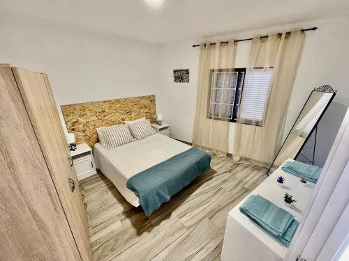 ein kleines Schlafzimmer mit einem Bett und einem Spiegel in der Unterkunft Casa Orbe in Garachico
