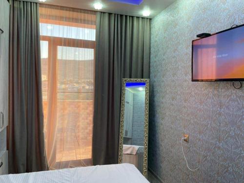 a bedroom with a mirror and a tv on the wall at My Sweet Home In Rustavi sity 2 in Rustavi