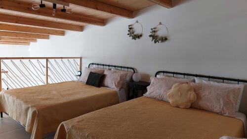sypialnia z 2 łóżkami i misiem na łóżku w obiekcie Argalios w mieście Kalamávka