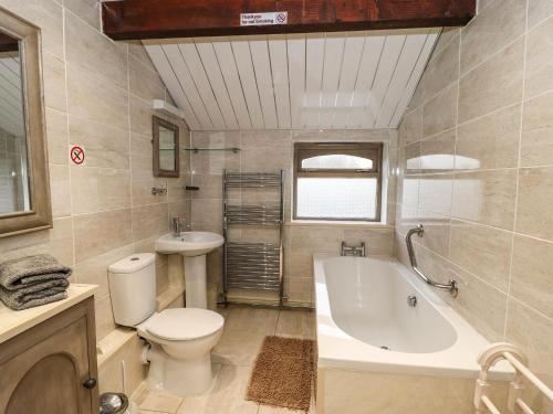 a bathroom with a tub and a toilet and a sink at Highview in Keighley