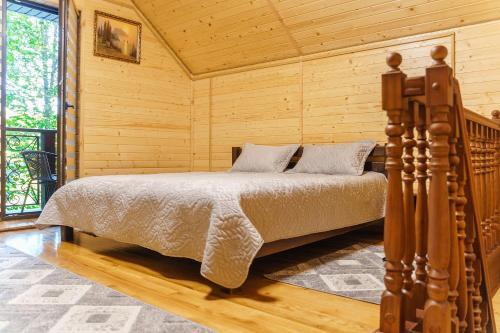 a bedroom with a bed in a wooden room at Готельно-ресторанний комплекс БОЖЕДАР in Vinnytsya