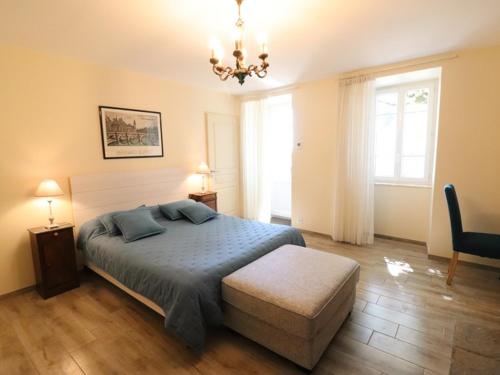a bedroom with a bed and a chandelier at Gîte Saint-Bonnet-de-Salers, 5 pièces, 9 personnes - FR-1-742-288 in Saint-Bonnet-de-Salers