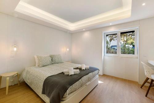 Un dormitorio blanco con una cama y una ventana. en Quiet Under The Trees, en Estoril
