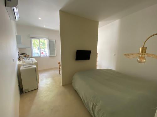 1 dormitorio con cama, mesa y ventana en Appartement cocooning l'ESCALE 2POST9 en Espira-de-lʼAgly