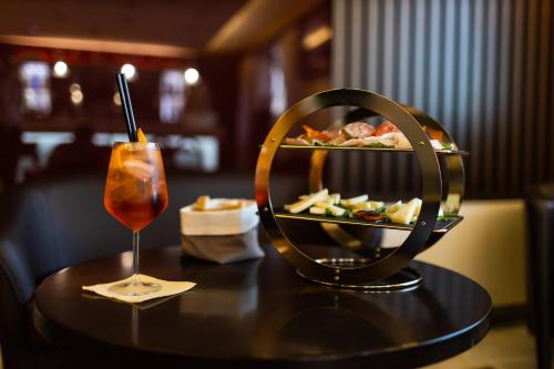 a table with a plate of food and a drink at Papillo Hotels & Resorts Roma in Rome