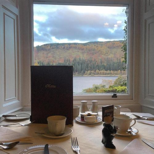 a dining table with a view of a window at Dale Head Hall Lakeside Hotel in Keswick
