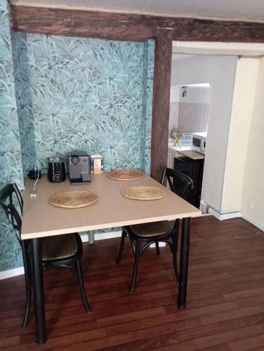 una mesa en una cocina con sillas alrededor en Appartement Thann côté vignoble, en Thann