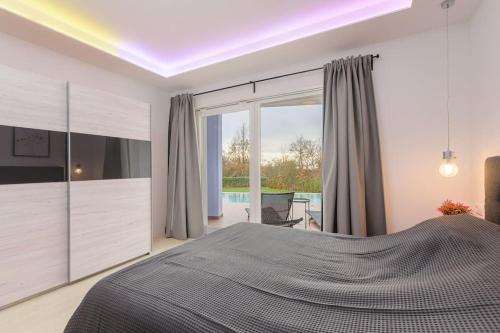 Un dormitorio con una cama grande y una ventana grande. en Villa Sicutti by IstriaLux, en Šivati