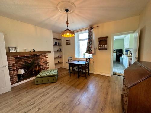 een woonkamer met een tafel en een open haard bij Idyllic Retreat in Dalton-In-Furness Sleeps 3! in Dalton in Furness