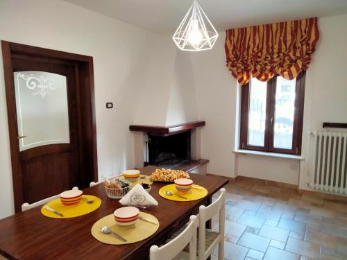 a dining room with a table with chairs and a fireplace at La Castellina 23 in Sulmona