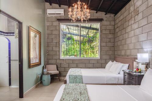 a bedroom with two beds and a window and a chandelier at Casa Madre Tierra in Valle de Anton