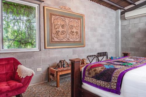 a bedroom with a bed and a red chair at Casa Madre Tierra in Valle de Anton