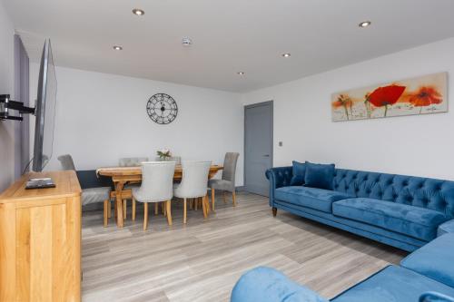 uma sala de estar com um sofá azul e uma mesa em Charles Alexander Short Stay - The Banks Apartments em Blackpool