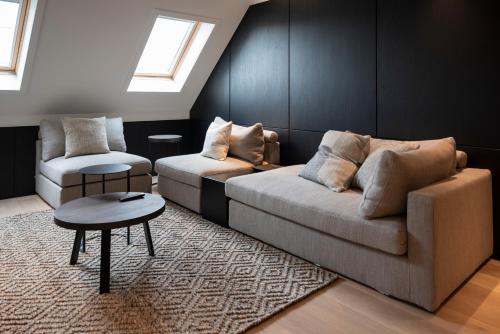 a living room with a couch and a chair at Cosmopolite Hotel Nieuwpoort-Bad in Nieuwpoort