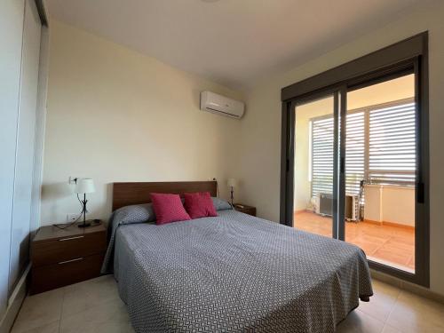 um quarto com uma cama com duas almofadas vermelhas em Kione Torresblancas em Torrenostra