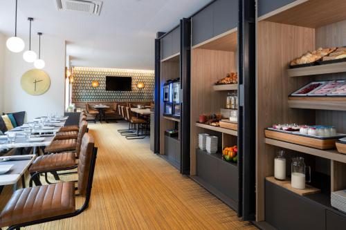 a restaurant with a dining room with tables and chairs at Aparthotel 37 Lodge Courbevoie Paris La Défense in Courbevoie