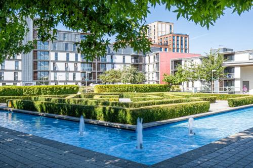 a hedge garden with buildings in the background at Cotels at Vizion Serviced Apartments, Superfast Broadband, Central Location, Free Parking, Fully Equipped Kitchen in Milton Keynes