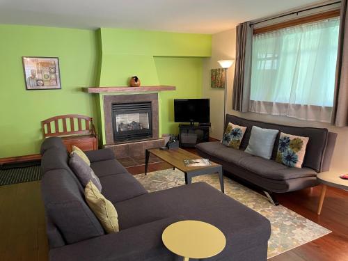a living room with a couch and a fireplace at Condo Jardins du Village Mont-Tremblant in Mont-Tremblant