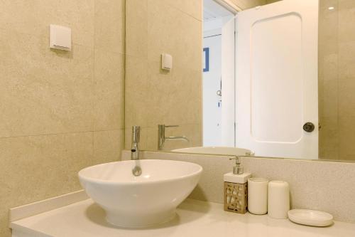 y baño con lavabo blanco y espejo. en Sea View Estoril, en Estoril