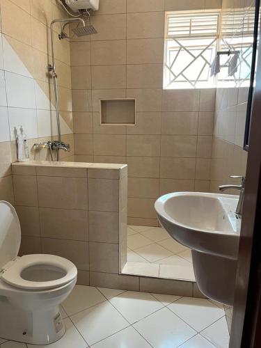 un baño con inodoro y lavabo en Vee's place, en Buwate