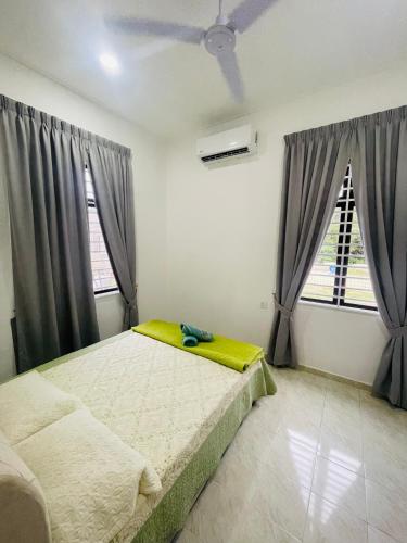 a bedroom with a bed and two windows at Homestay CikguMa - Netflix & Wifi in Kota Bharu