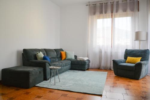 sala de estar con sofá y 2 sillas en "La Villa dei Nonni" appartamento, en Bérgamo