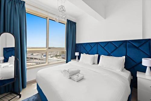 - une chambre avec un grand lit blanc et une fenêtre dans l'établissement StoneTree - Stylish 1BR near Marina Walk, à Dubaï