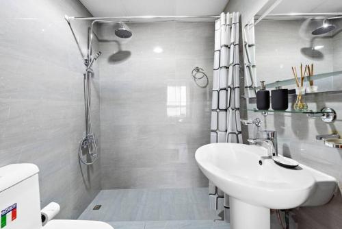 a white bathroom with a sink and a toilet at StoneTree - Stylish 1BR near Marina Walk in Dubai