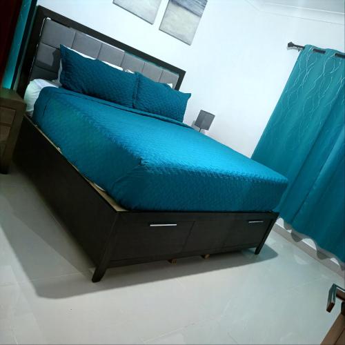 1 cama con edredón azul y almohadas azules en Vista cana, en Punta Cana