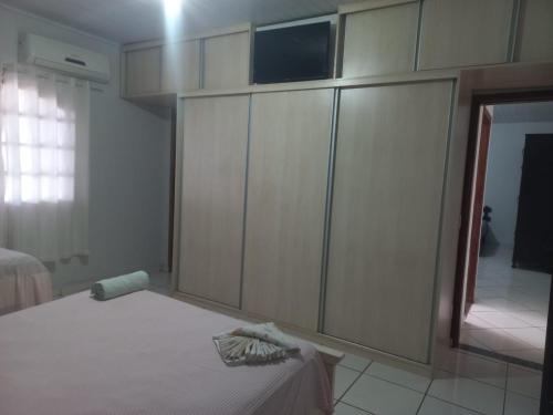 a bedroom with a bed and a tv on top of cabinets at Suits - Canto do sabia in Brotas