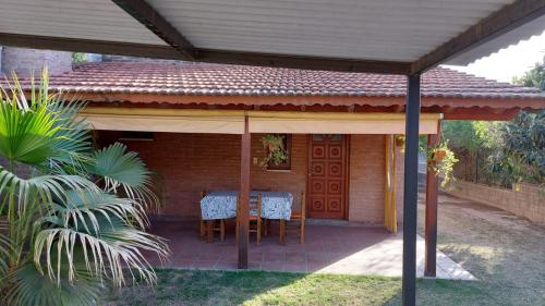 un patio con mesa y sillas bajo un techo en Departamentos corrientes en Santa Rosa de Calamuchita