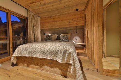 a bedroom with a bed in a room with wooden walls at Epicime Lodge in Landry