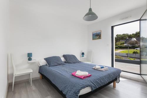 biała sypialnia z łóżkiem i oknem w obiekcie Maison Quenvel Morgat - À 5min de la plage w mieście Crozon
