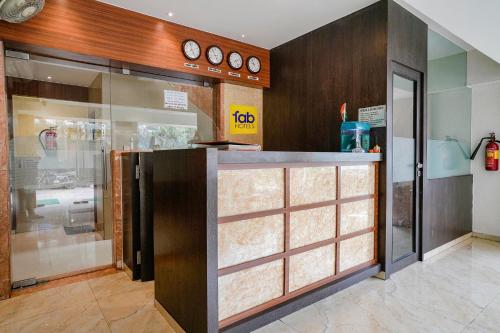 a kitchen with a counter with clocks on the wall at Super Capital O Hotel Konar Inn in Turambhe