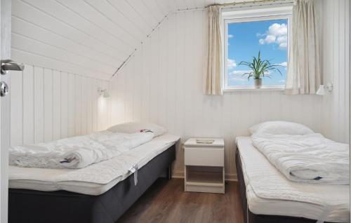 twee bedden in een kamer met een raam bij Lovely Home In Fan With Private Swimming Pool, Can Be Inside Or Outside in Fanø