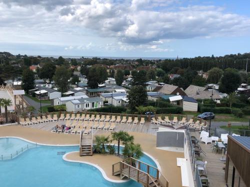 - une vue sur la piscine et la plage d'un complexe dans l'établissement Mobil home 6 personnes dans camping 5*, à Houlgate