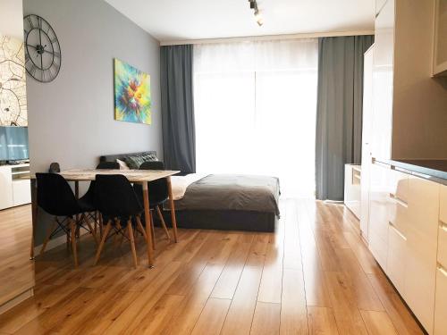 a room with a table and a bed and a kitchen at NOVUM Apartment in Krakow