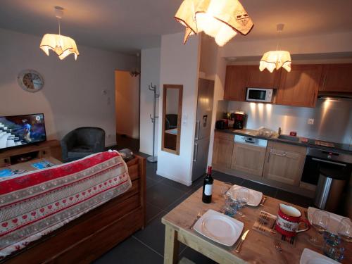 - un salon avec une cuisine et une table avec une bouteille de vin dans l'établissement Appartement 3 pièces 4 pers, 3 étoiles, Exposé Sud avec Terrasse - Valloire, à Proximité des Pistes - FR-1-263-338, à Valloire