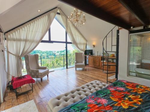 a bedroom with a bed and a large window at Bird Nest - Hanthana in Kandy