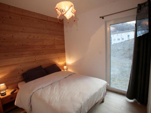 une chambre avec un lit et une grande fenêtre dans l'établissement Appartement 3 pièces 4 pers, 3 étoiles, Exposé Sud avec Terrasse - Valloire, à Proximité des Pistes - FR-1-263-338, à Valloire