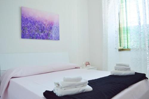um quarto branco com uma cama com toalhas em “La Casa di Margi” em Nápoles