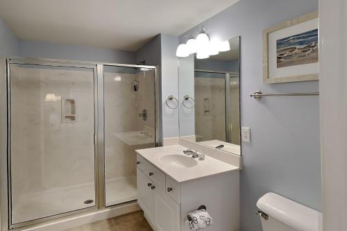 a white bathroom with a sink and a shower at The Village 514 in Blue Mountain Beach