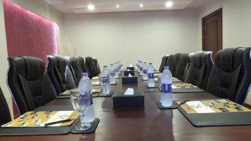 a conference room with a long table and bottles of water at Panacea Suites Hotel in Borg El Arab
